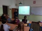 Lekcja w Szkole Podstawowej nr 8 w Goleniowie, klasa szkolna, uczniowie, ekran, godło, funkcjonariuszka