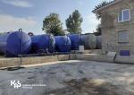 Rząd połączonych pojemników przeznaczonych do przechowywania produktów w postaci płynnej ustawionych przy budynku
