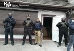 czterech funkcjonariuszy służby celno-skarbowej stoi przed nielegalnym punktem hazardowym