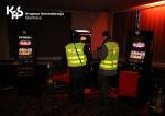 Funkcjonariusze zachodniopomorskiej KAS wewnątrz lokalu stoją przy automacie z nielegalnymi grami hazardowymi.