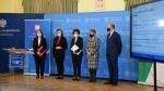 Szef KAS Magdalena Rzeczkowska, Minister rodziny i polityki społecznej Marlena Maląg, Prezes ZUS prof. Gertruda Uścińska stoją na tle ścianki po zakończonej konferencji
