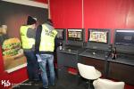dwóch funkcjonariuszy służby celno-skarbowej we wnątrz lokalu, widoczne cztery stanowiska komputerowe służące go gier hazardowych