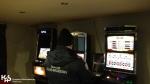 funkcjonariusz służby celno-skarbowej stoi przed trzema nielegalnymi automatami do gier hazardowych 