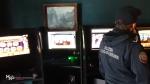 Na zdjęciu widać funkcjonariusza Służby Celno-Skarbowej, który znajduje się w lokalu na tle automatów do gier.