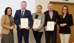 Wyróżnieni naczelnicy urzędów skarbowych trzymają w rękach dyplomy w obecności Dyrektora i Zastępcy Dyrektora Izby Administracji Skarbowej w Szczecinie