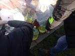 funkcjonariusze służby celno-skarbowej przy wystawionych baniakach z nielegalnym alkoholem