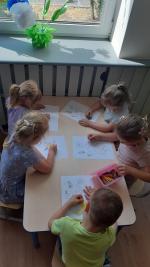 dzieci kolorują wydrukowane kartki