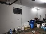 garaż wykorzystywany do produkcji nielegalnego alkoholu, na podłodze, wiadra, baniaki i beczka wypełnione alkoholem