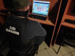 funkcjonariusz służby celno-skarbowej przed monitorem wykorzystywanym do nielegalnych gier hazardowych