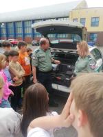 Uczniowie oglądają prezentację wyposażenia funkcjonariuszy