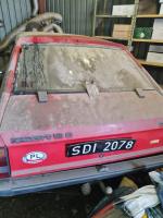 Samochód osobowy Opel Kadett, w kolorze czerwonym akryl, bardzo zniszczony, brudny wewnątrz i na zewnątrz.