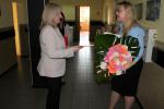Na korytarzu urzędu dyrektor wręcza kwiaty dotychczasowej naczelnik urzędu