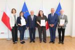 Zdjęcie grupowe, na którym stoją zastępca dyrektora oraz wyróżnieni naczelnicy urzędów skarbowych i kierownicy obsługi bezpośredniej.