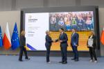 Przedstawiciele Urzędu Skarbowego w Choszcznie stoją na scenie wraz z Ministrem Finansów i Szefem Krajowej Administracji Skarbowej
