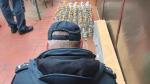 Funkcjonariusz Służby Celno-Skarbowej pochylony nad ujawnionym i zabezpieczonym alkoholem bez polskich znaków akcyzy