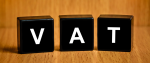3 czarne sześciany z literami tworzącymi napis VAT